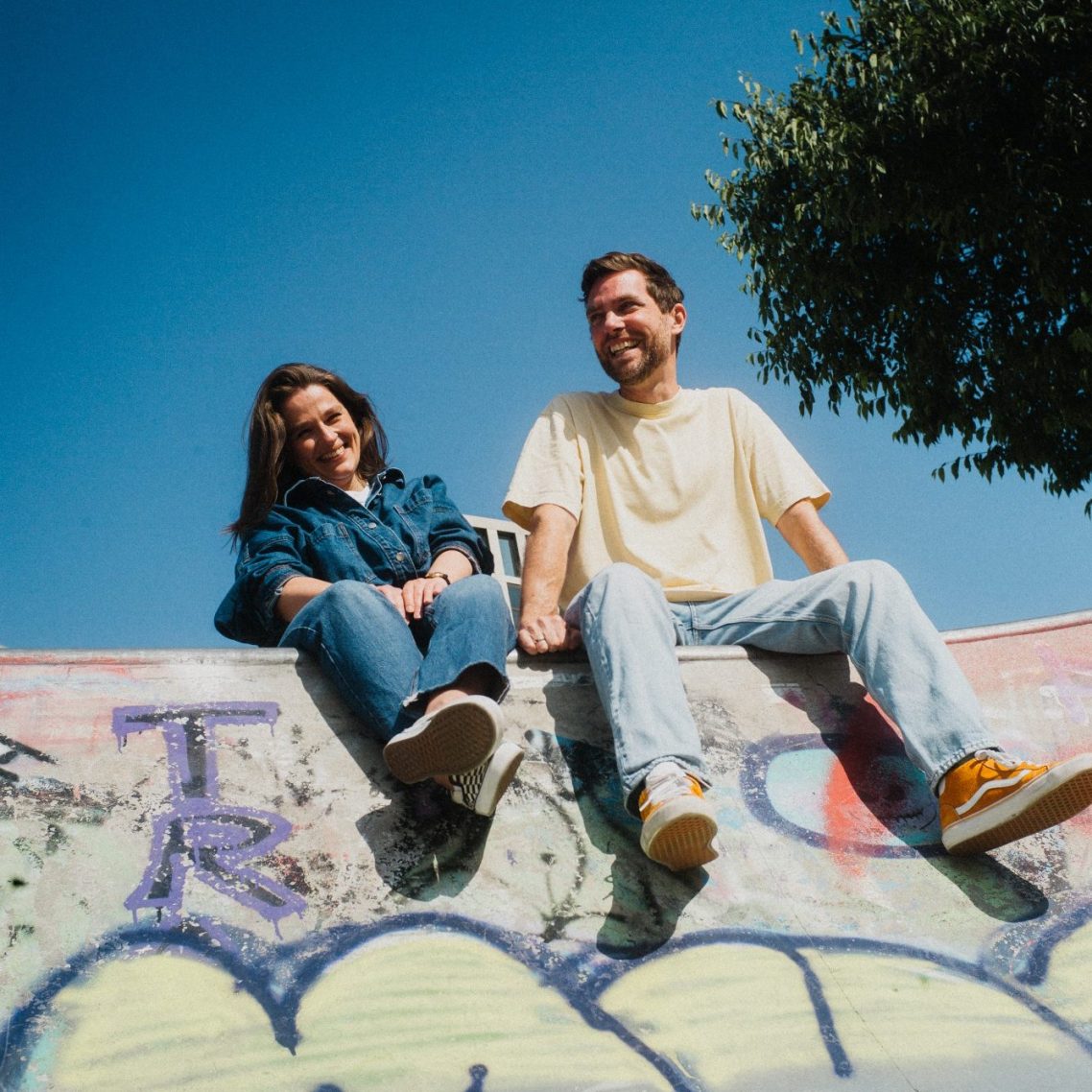 Andrea Engel hängt kopfüber an einem Spielgerät, Frank Röhrig steht lässig daneben.